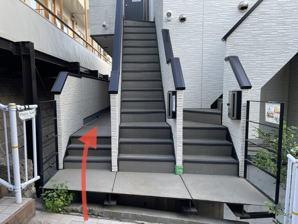 ティーラが入っている建物の入り口。各フロアに進む3つの階段が並んでいます。一番左の3段の階段に進む指示の矢印画像が貼り付けてあります。