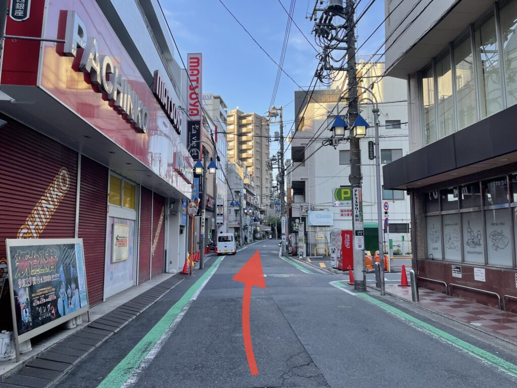 道なりの写真。左にパチンコ屋さんがあります。直進する指示の矢印画像が貼り付けてあります。